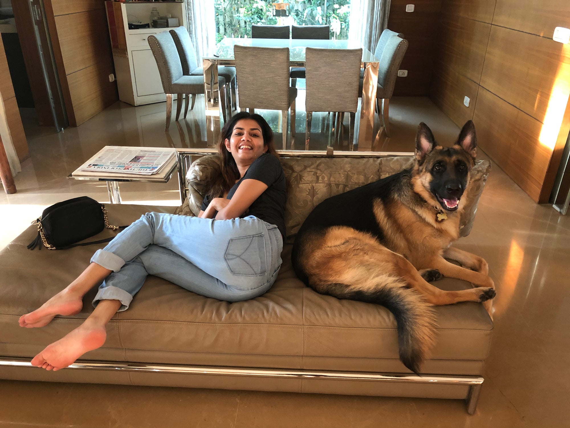 woman sitting on couch with german shepherd dog